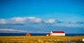 Icelalndic farm house and shed with bright red roof and snow cap