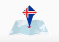 Iceland is depicted on a folded paper map and pinned location marker with flag of Iceland