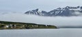 Hrisey Island under the snowy mountains and fog in Eyjafjordur, Iceland