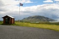 Iceland, 2008, June, Icelandic flag on a filed with a mountain in the background