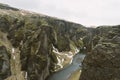 Iceland landscape photography. Picture of gorge FjaÃÂ°rÃÂ¡rgljÃÂºfur Fjadrargljufur. Moody clouds in the background and a river.