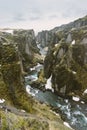 Iceland landscape photography. Picture of gorge FjaÃÂ°rÃÂ¡rgljÃÂºfur Fjadrargljufur. moody clouds in the sky and a river.