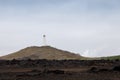 Iceland lighthouse Reykjanesviti with rocky volcanic soil and grey sky