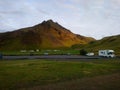 Iceland mountain landscape sky clouds cliff green morning yellow car caravan