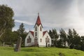 Iceland. Old rural church with red roof, cemetery, cloudy sky, summer, empty space above. Royalty Free Stock Photo