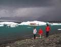 Iceland, Reykjavik, July 3, 2016: two boys and his mather walking in red clothes on the coast line of famous Jokulsarlon lagoon i
