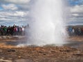 ICELAND, STROKKUR, JULY 26, 2016: Strokkur geysir eruption Golden Circle, big group of colorful dressed tourist takeing pictures