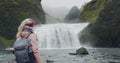 Iceland, woman with backpack enjoying Stjornarfoss waterfall near Kirkjubaejarklaustur