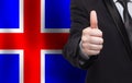 Icelandic concept. Businessman showing thumb up on the background of flag of Iceland