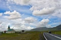 Icelandic countryside view, small villages and churches in the middle of nature, black cars driving on asphalt road Royalty Free Stock Photo