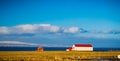 Icelandic farm house and shed with bright red roof and snow cap