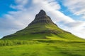 Icelandic landscape with Kirkjufell mountain and green meadow