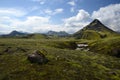 Icelandic mountains and green lush meadow and creek and blue sky Royalty Free Stock Photo