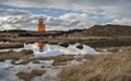 Icelandic Orange Lighthouse Reflecting in Pool of Water