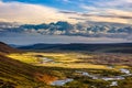 Icelandic rural panorama with grey clouds, green fields, hills a