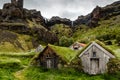 Icelandic turf houses and rocks with waterfall in the background Royalty Free Stock Photo