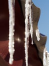 An icicle illuminated by sunlight against the roof Royalty Free Stock Photo