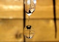 Icicle melting with falling drop of water on the background of wooden wall