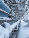 Icicles adorn the blue machinery of a snow-filled textile factory, painting a picture of a serene but frozen industrial