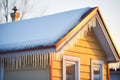 icicles backlit by the setting sun on a house eave