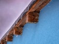 Icicles on the edge of the roof - Blurred snowflakes in motion Royalty Free Stock Photo