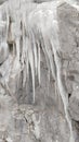 Icicles flow over pale pink bedrock