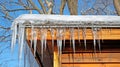 Icicles formed by dripping frozen water hanging from a roof in the winter season Royalty Free Stock Photo
