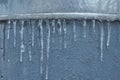 Icicles hanging down, dripping. Winter to spring. Shallow depth of field. pattern of ice crystal hanging un a peace of wood.