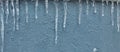 Icicles hanging down, dripping. Winter to spring. Shallow depth of field. pattern of ice crystal hanging un a peace of wood.