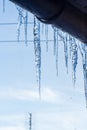 Icicles hanging from roof of house. Winter concept. Closeup danger icicles. Frozen climate pattern. Frost winter