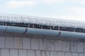 Icicles hanging from roof of house. Winter concept. Closeup danger icicles. Frozen climate pattern. Frost winter