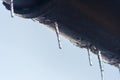 Icicles hanging from roof of house. Winter concept. Closeup danger icicles. Frozen climate pattern. Frost winter