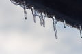 Icicles hanging from roof of house. Winter concept. Closeup danger icicles. Frozen climate pattern. Frost winter