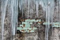 Icicles hanging from the roof of the old brick building with cubes of old tiles, traumatic acrid ice, thaw in the early spring, se