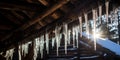 Icicles hanging from the roof of an old log hut -, concept of Winter wonderland Royalty Free Stock Photo