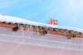 Icicles hanging on the roof under the bright sunrays of spring Royalty Free Stock Photo