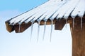 Icicles hanging from the roof of a wooden hut Royalty Free Stock Photo