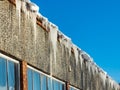 Icicles hanging from rooftop covered with a lot of snow Royalty Free Stock Photo