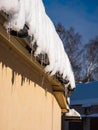 Icicles hanging from rooftop covered with a lot of snow Royalty Free Stock Photo