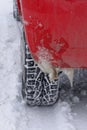 Icicles on rear fender red car in winter. Spiked tire for snow riding. Cold and bad weather driving concept Royalty Free Stock Photo