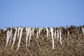 Icicles retro straw roof background blue sky Royalty Free Stock Photo