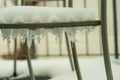Icicles and snow on a chair on a balcony Royalty Free Stock Photo