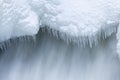 Icicles and snow near flowing water