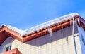 Icicles and snow on the roof of the house Royalty Free Stock Photo