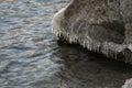 Icicles on stone on the beach in sunny winter day Royalty Free Stock Photo