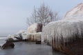 Icicles on the stones on the freezing river in autumn