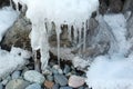 Icicles on stones at the thawing river