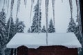 Icicles. View from a cottage window in heavy winter in the mountains Royalty Free Stock Photo