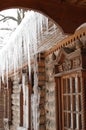 Icicles in winter. Icicles on a wooden hut. Wooden house in ice. Ice covers the log walls and icicles hang from the roof Royalty Free Stock Photo