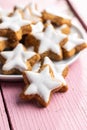 Icing gingerbread stars. Traditional Christmas cookies on pink wooden table Royalty Free Stock Photo